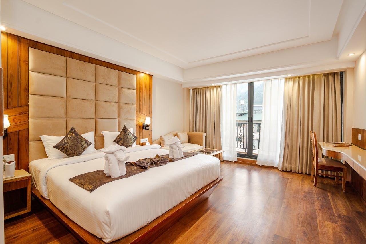 Spacious and elegant hotel room with a king-size bed and large window view.