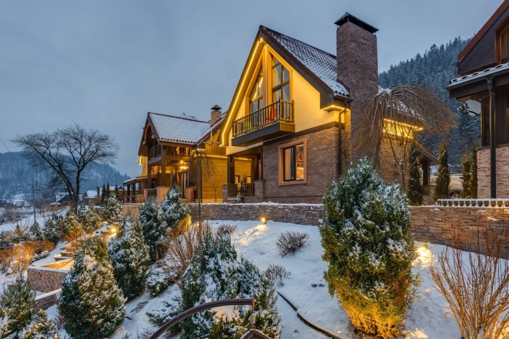 Warmly lit chalet surrounded by snow-covered trees in a picturesque winter setting.